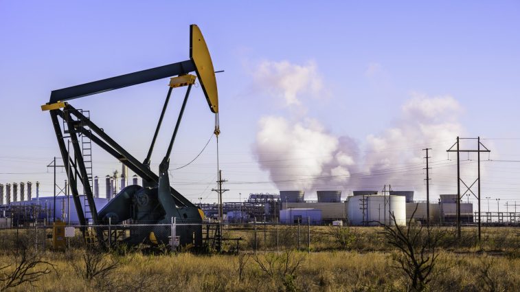 A pumpjack (oil derrick) and oil refinery in Seminole, West Texas.
