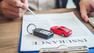 Keys and toy red car on an insurance policy