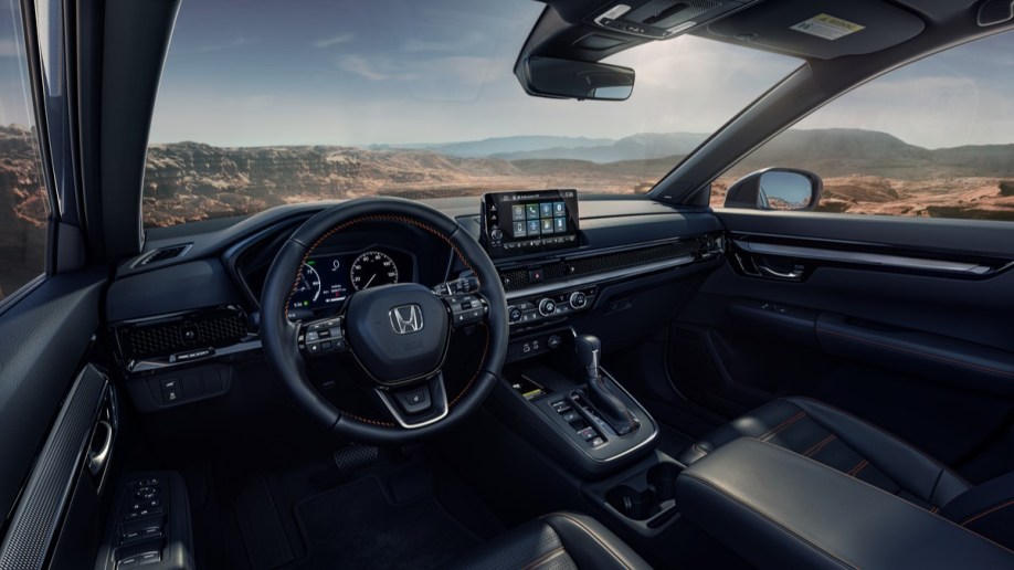 The cabin of the 2023 Honda CR-V. It is upholstered in black leather, with a 9-inch touchscreen standing out from the dashboard.