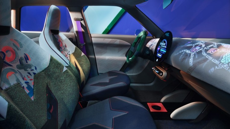 The cabin of the Mini Aceman concept. Its seats are upholstered in many fabrics cut at odd angles,including one in blue denim and one with neon X's and O's. The dashboard has moving multicolored words projected onto it.
