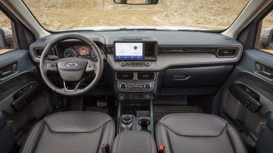 The interior of the Ford Maverick Tremor. The seats are black leatherette, with bright orange stitching.