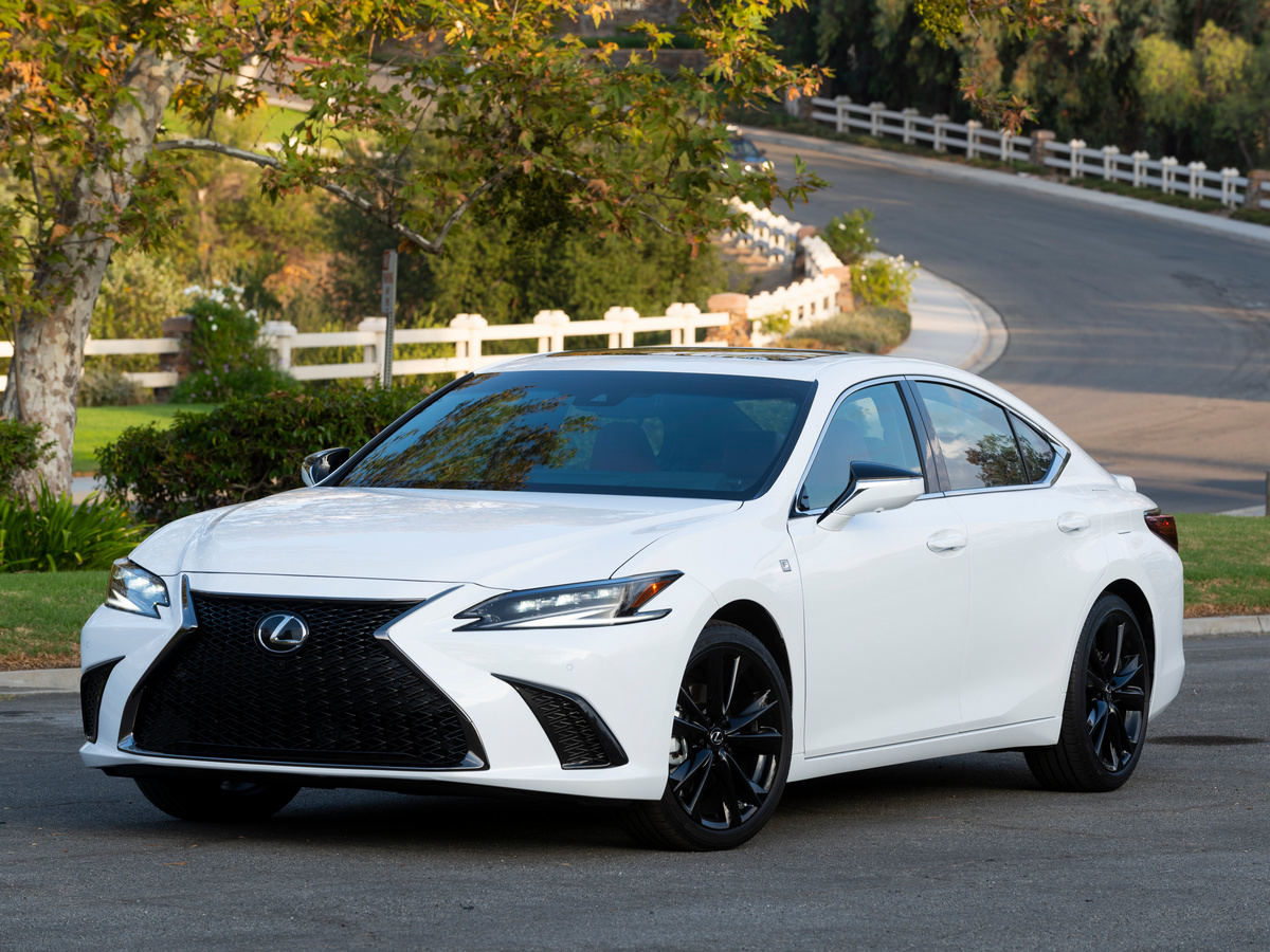 White 2023 Lexus ES 300h parked near curved fence