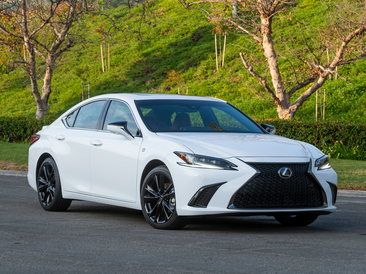 White 2023 Lexus ES 300h parked near green hill