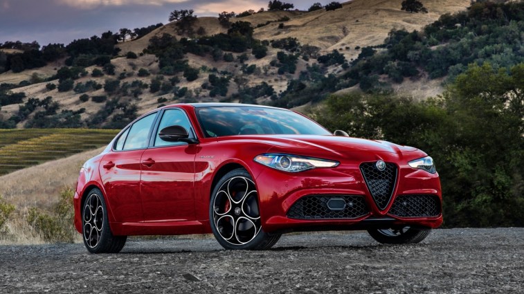 Red 2023 Alfa Romeo Giulia on gravel near hillside