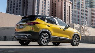 Gold 2023 Kia Seltos parked near office buildings