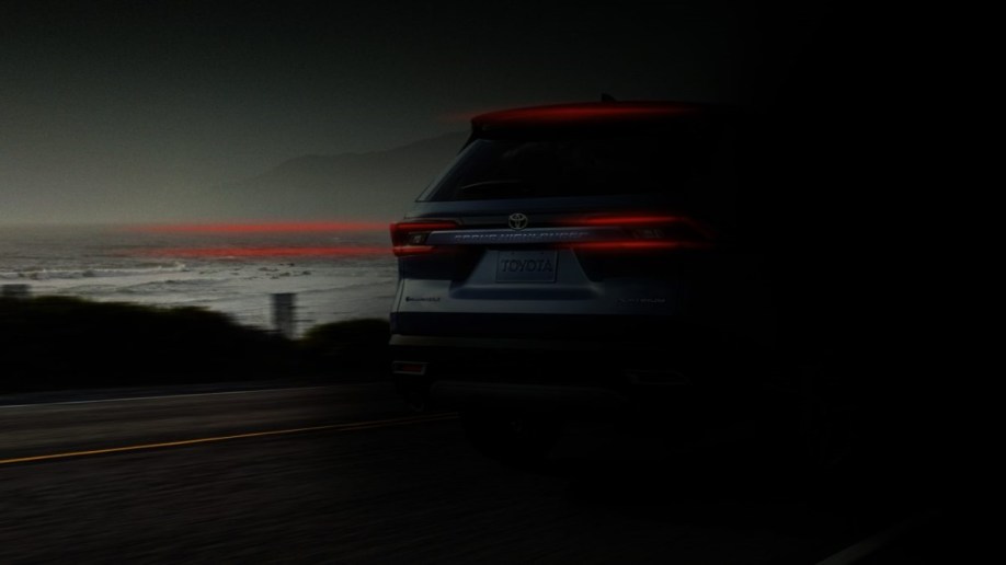 A teaser photo showing the rear of the 2024 Toyota Grand Highlander obscured by shadows