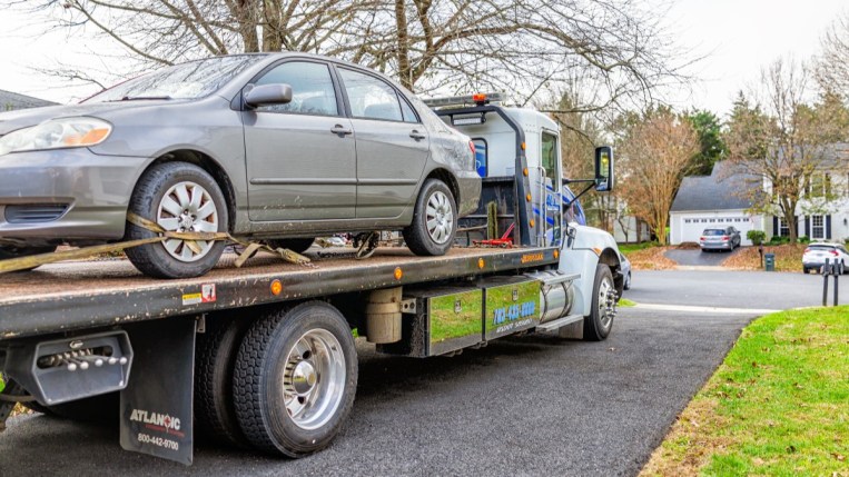 A car mounted on a flatbed tow truck