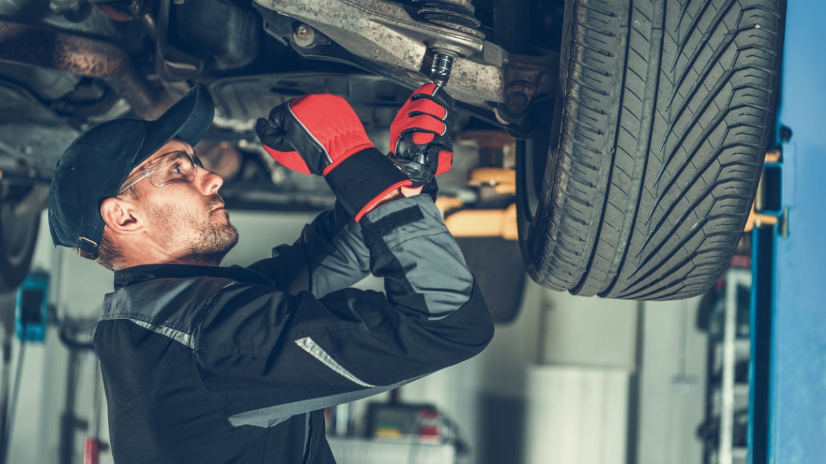A technician working on a shocks and struts repair