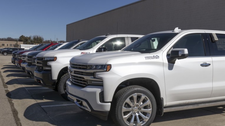 A line of 2023 Chevrolet Silverado pickups outside a factory