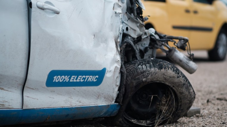 A closeup of a damaged electric car's wheel
