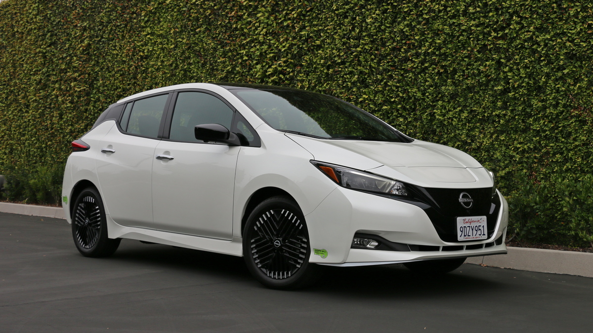 White 2023 Nissan Leaf near ivy wall.