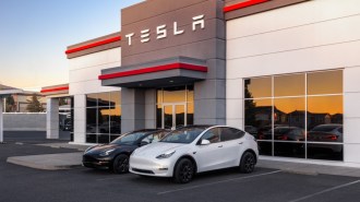 A Tesla Model Y and Model 3 sit outside a sales center