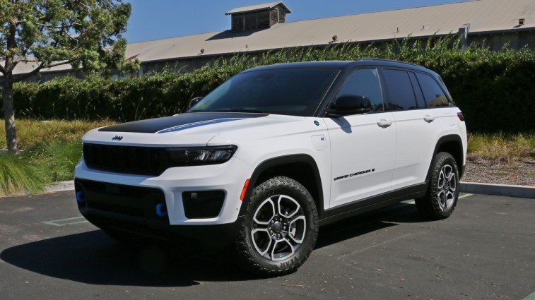 2023 Jeep Grand Cherokee Trailhawk 4xe in white with a hedge in background.