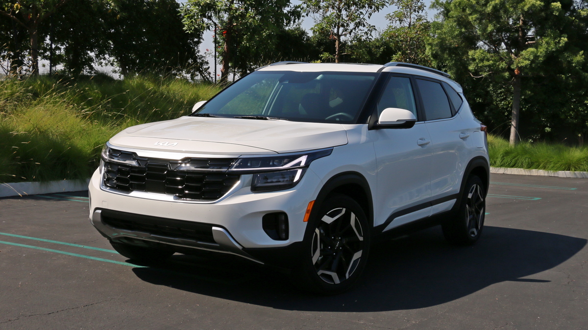 2024 Kia Seltos SX in white near grass and trees.