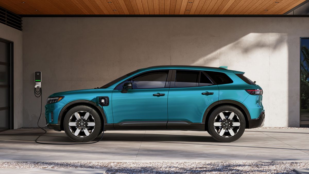 2024 Honda Prologue Elite in blue profile view charging in a carport.