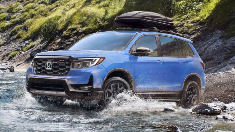 2024 Honda Passport TrailSport in silver driving through water.