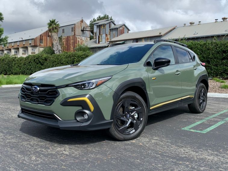 2024 Subaru Crosstrek Sport in green with a metal barn in the background.