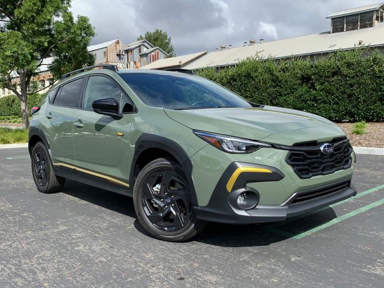 2024 Subaru Crosstrek Sport in green with a metal barn in the background.