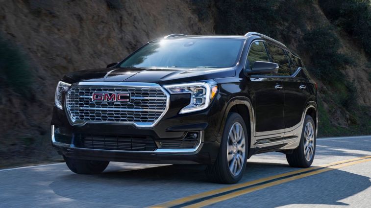 2024 GMC Terrain Denali in Ebony Twilight Metallic driving on road.