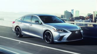 2024 Lexus ES 350 in silver driving down a street.