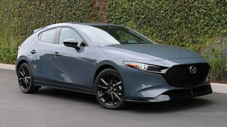 2024 Mazda3 2.5 Turbo Premium Plus in Polymetal Grey Metallic. near an ivy wall.