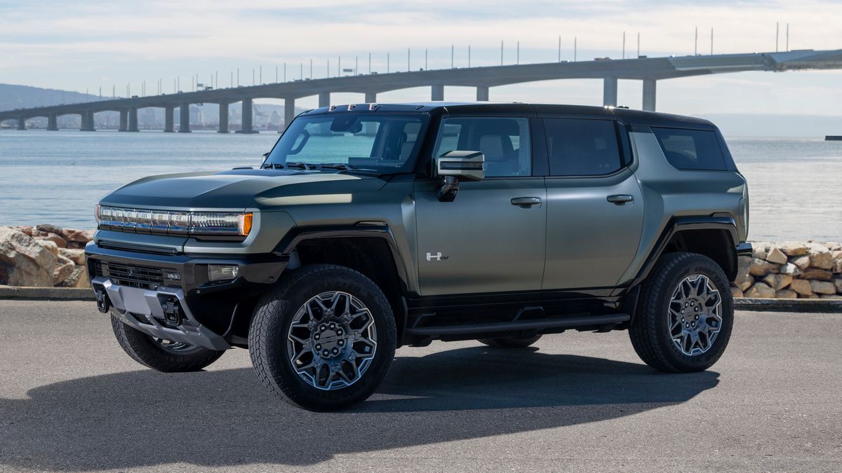 2024 GMC HUMMER EV SUV in Moonshot Green Matte parked near water and a bridge.