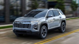 2025 Chevrolet Equinox LT in Sterling Gray Metallic driving down the road.
