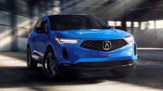 2024 Acura RDX in blue driving in a warehouse.
