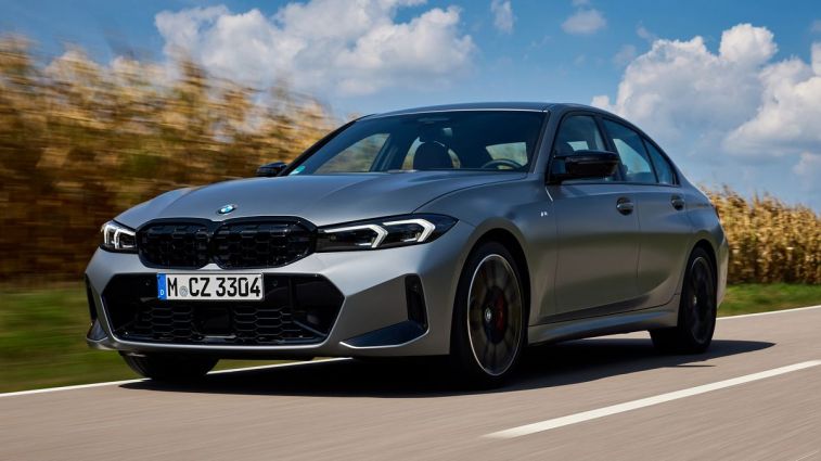2024 BMW M340i in silver driving down a road next to a cornfield.