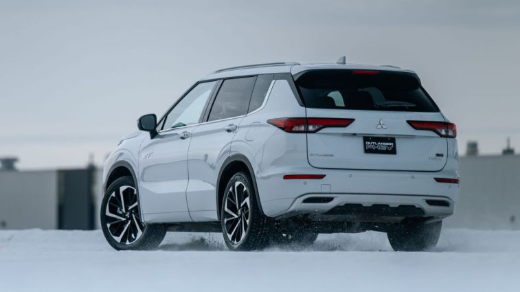 Rear view of the 2024 Mitsubishi Outlander PHEV driving on snow