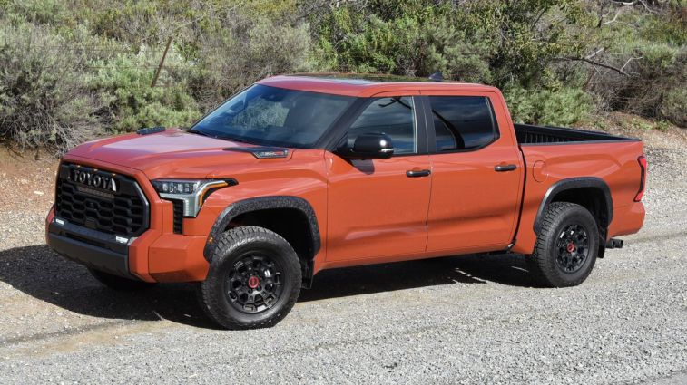 2024 Toyota Tundra TRD Pro parked on gravel with shrubs in the background.