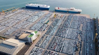 Cars lined up in port, awaiting transport onto car carrier ships