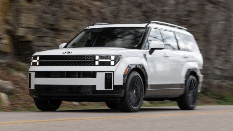 2024 Hyundai Santa Fe in white driving on a road.