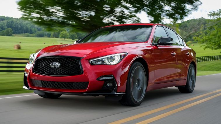 2024 Infiniti Q50 S in red driving through the countryside.