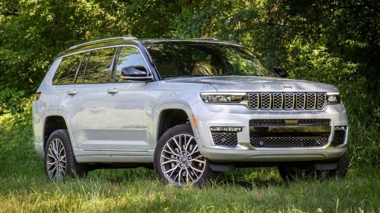 2024 Jeep Grand Cherokee L Summit Reserve parked amongst trees and grass.