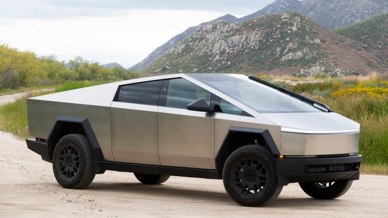 2024 Tesla Cybertruck on a dirt road with hills in the background.