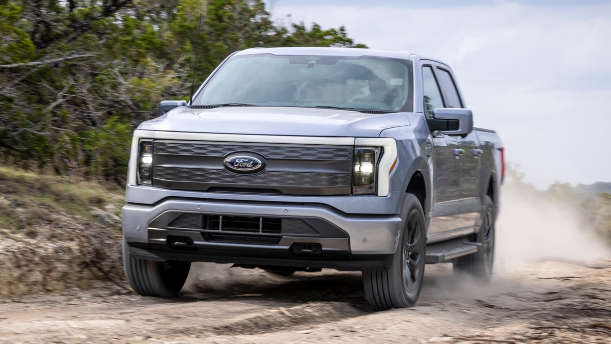 2024 F-150 Lightning Lariat driving on a dirt road.