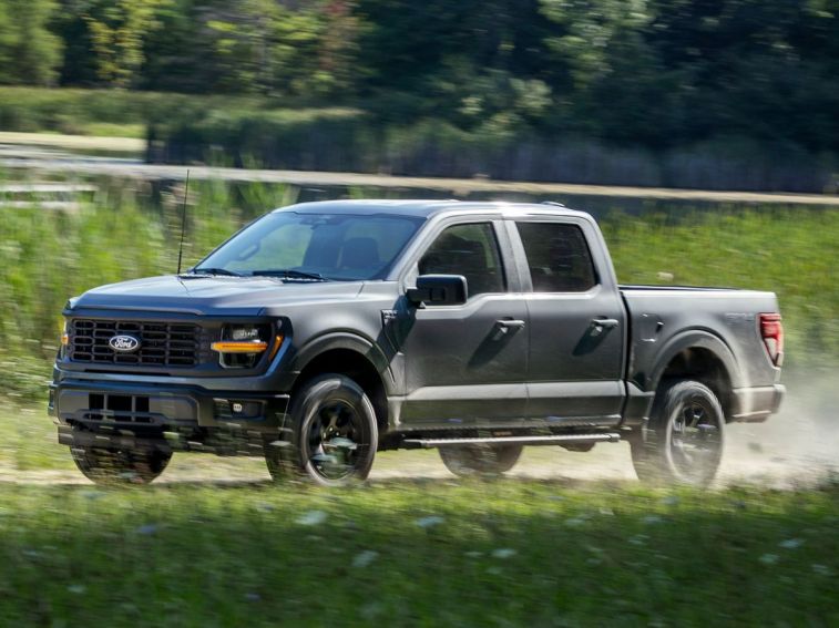 2024 Ford F-150 STX driving on a dirt road.