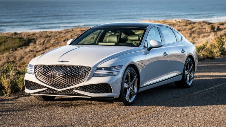 2024 Genesis G80 in white with the ocean in the background.