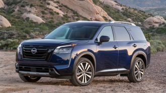 2024 Nissan Pathfinder in blue with rock formations in the background.
