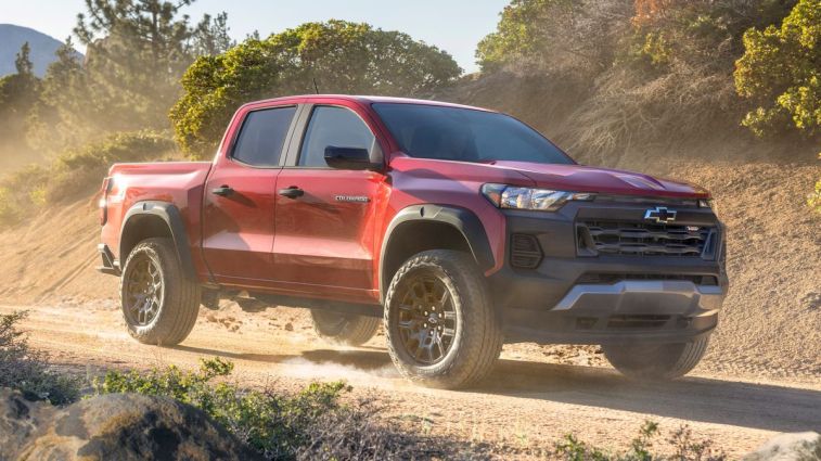 2024 Chevrolet Colorado Trail Boss driving down a dirt road during golden hour.