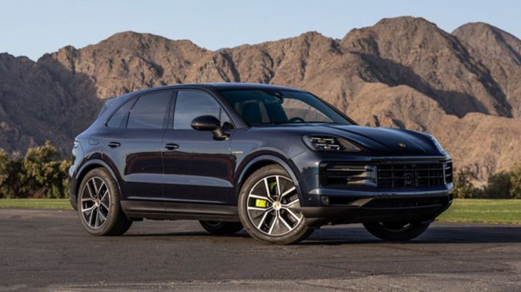 2024 Porsche Cayenne E-Hybrid in Algarve Blue with mountains in the background.