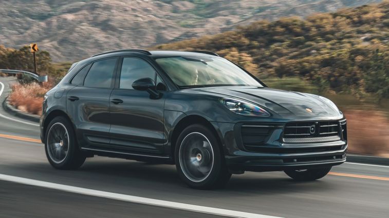 2024 Porsche Macan in Volcano Grey driving on a mountain road.