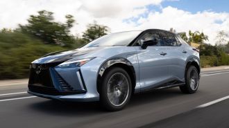 2024 Lexus RZ 450e driving on a road.