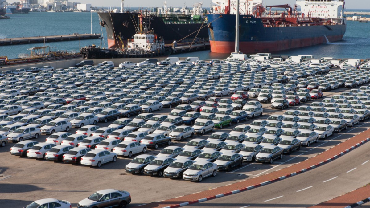 Cars parked in a port near roll-on/roll-off container ships